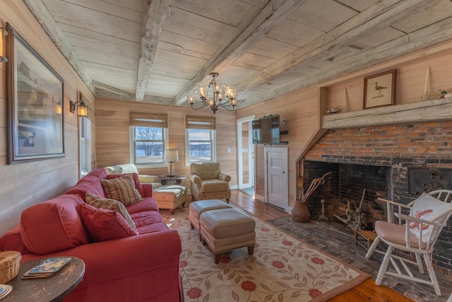 living room with wood finished floors, a notable chandelier, wood walls, and a fireplace