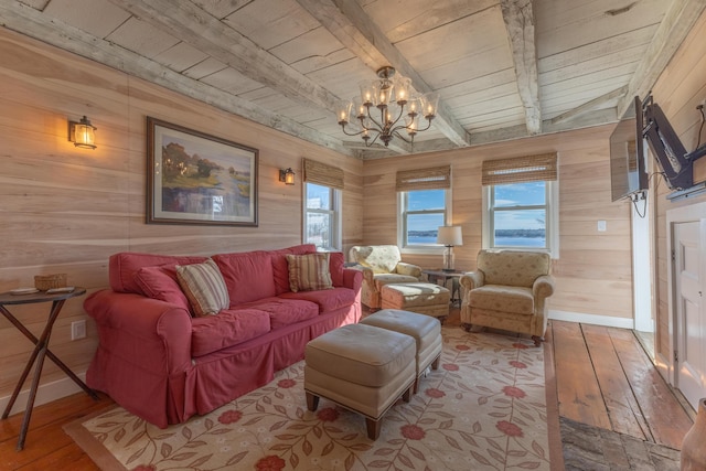 living room with wood walls, hardwood / wood-style floors, beam ceiling, wooden ceiling, and a notable chandelier