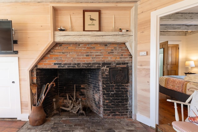 interior details featuring wooden walls and a brick fireplace