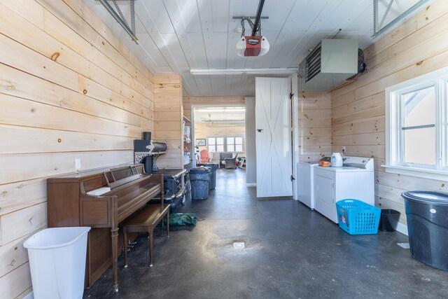 garage with wooden walls, a garage door opener, and separate washer and dryer