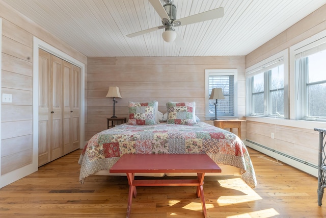 bedroom featuring baseboard heating, wood ceiling, and light wood-style floors