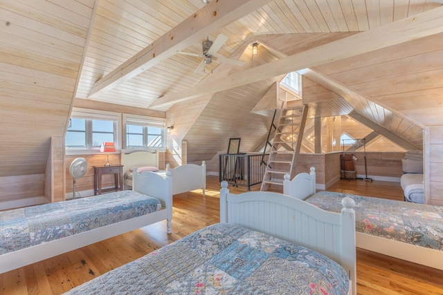 bedroom featuring lofted ceiling with beams, wooden walls, hardwood / wood-style floors, and wooden ceiling