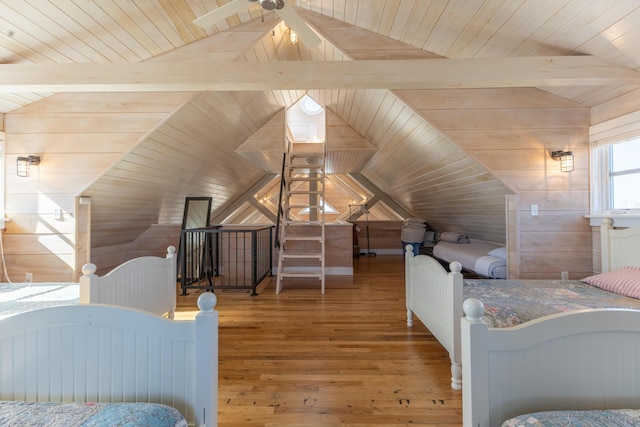 bedroom with wood ceiling, vaulted ceiling with beams, wood finished floors, and wood walls