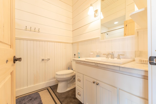 full bathroom featuring vanity, curtained shower, toilet, and wood walls