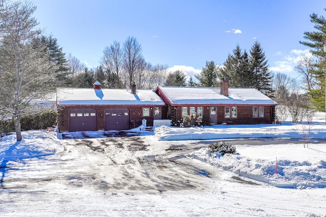 ranch-style house featuring an attached garage, a chimney, and cooling unit