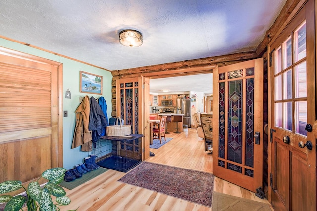 entrance foyer with crown molding, a textured ceiling, and wood finished floors