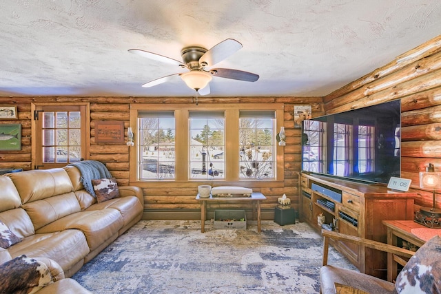 living area with ceiling fan and a textured ceiling