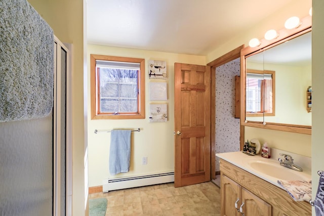 full bathroom with a shower stall, baseboard heating, and vanity