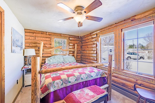 carpeted bedroom featuring log walls, a ceiling fan, and baseboards