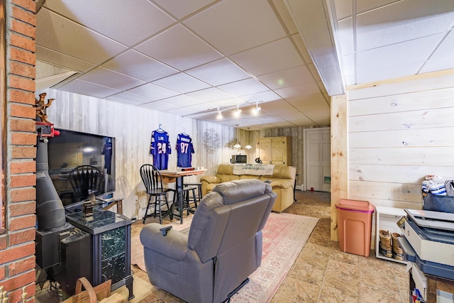 living room featuring wood walls and a paneled ceiling