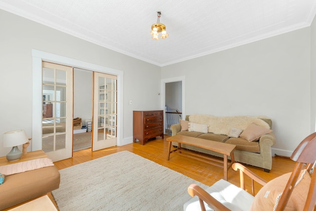 living area featuring ornamental molding, light wood-type flooring, french doors, and baseboards