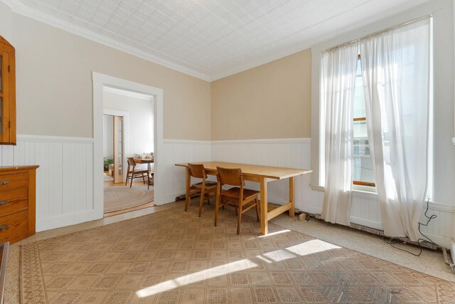 dining area featuring crown molding and wainscoting