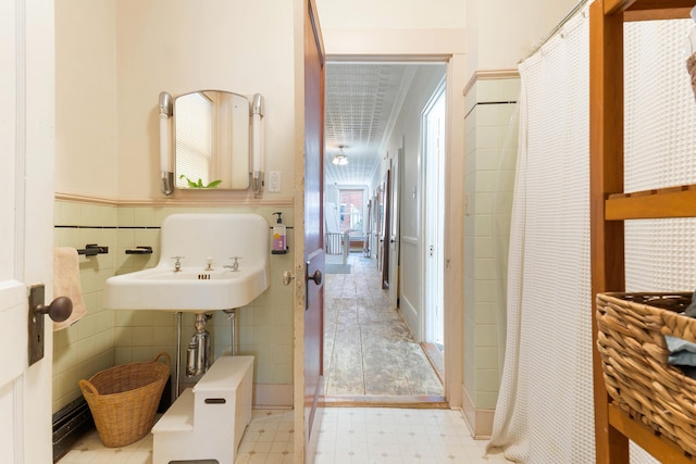 full bath featuring curtained shower, wainscoting, tile walls, and tile patterned floors