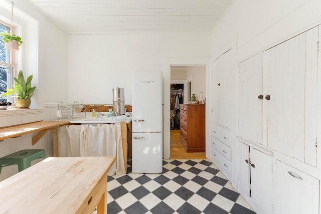 kitchen with light floors, light countertops, and wainscoting