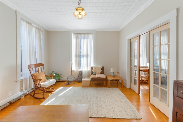 living area with baseboards, french doors, and light wood-style floors