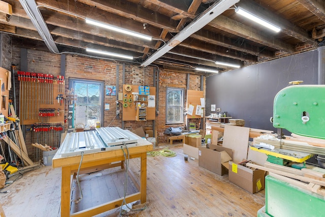 basement with brick wall and wood-type flooring