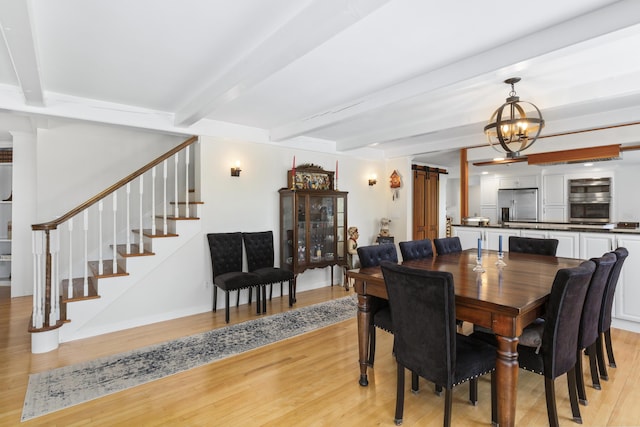825 Hendricks Hill Rd, Southport, ME 04576 - dining area with stairway, light wood-style floors, a chandelier, and beamed ceiling