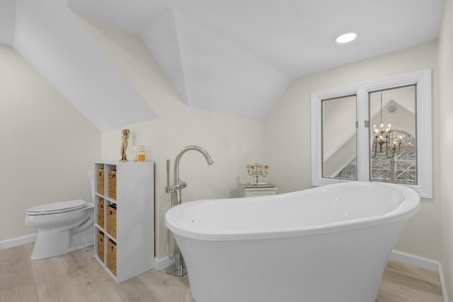 825 Hendricks Hill Rd, Southport, ME 04576 - bathroom with toilet, wood finished floors, a freestanding bath, vaulted ceiling, and baseboards