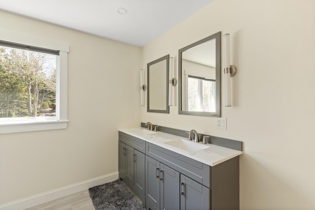 825 Hendricks Hill Rd, Southport, ME 04576 - bathroom with double vanity, baseboards, and wood finished floors