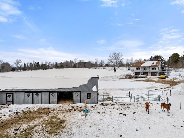 yard layered in snow with a pole building, fence, and an outdoor structure