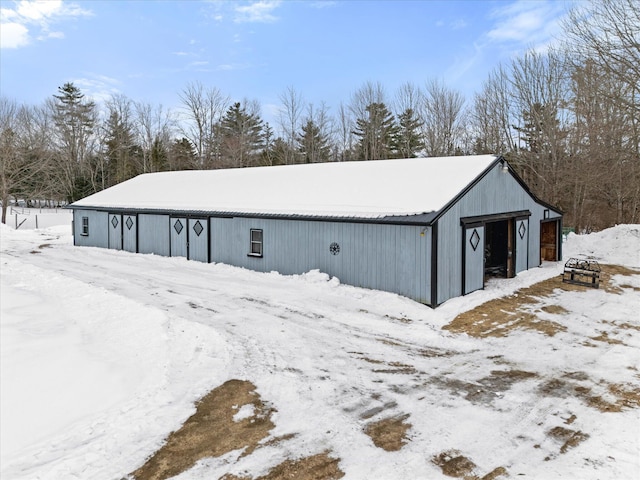 snow covered structure with an outbuilding and a pole building