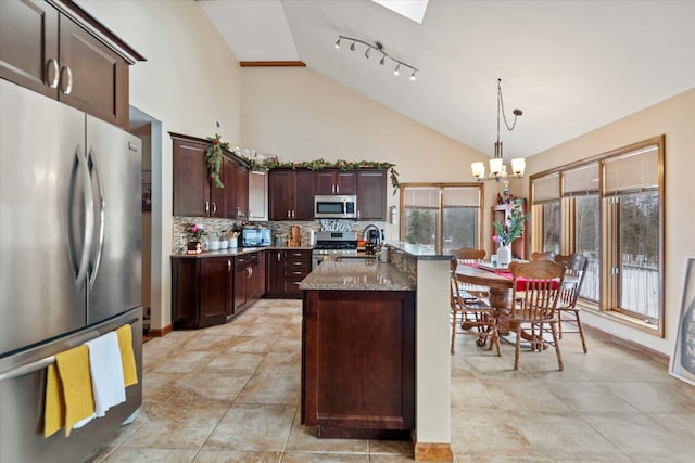 kitchen with decorative backsplash, decorative light fixtures, stainless steel appliances, stone counters, and a chandelier