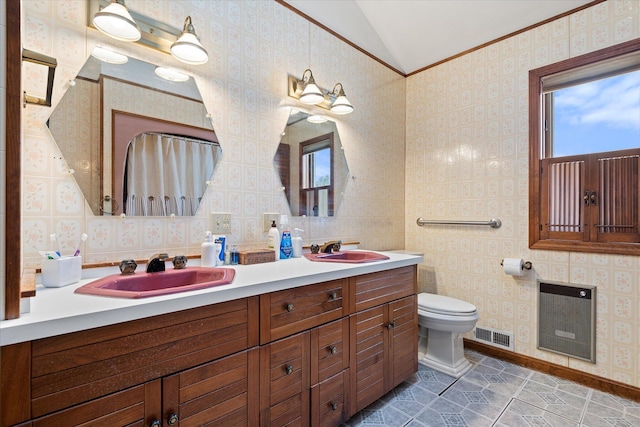 bathroom featuring heating unit, wallpapered walls, visible vents, and a sink