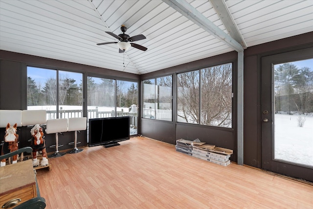 sunroom featuring a ceiling fan, lofted ceiling, and a healthy amount of sunlight