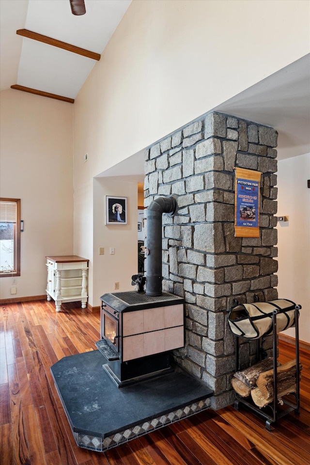 room details with a wood stove, baseboards, and wood finished floors