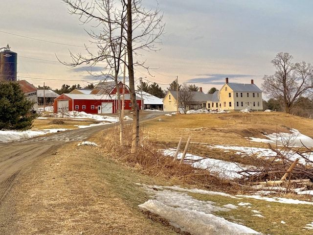 view of front of home with dirt driveway and a garage