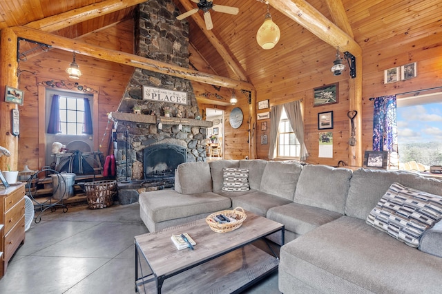 living area featuring beamed ceiling, wooden walls, and finished concrete floors