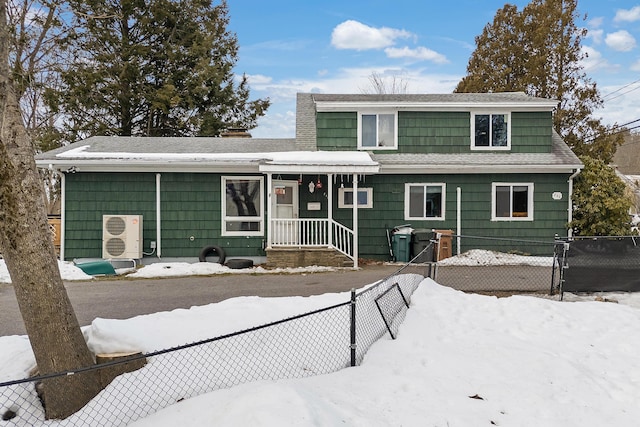 view of front of house with a shingled roof and fence