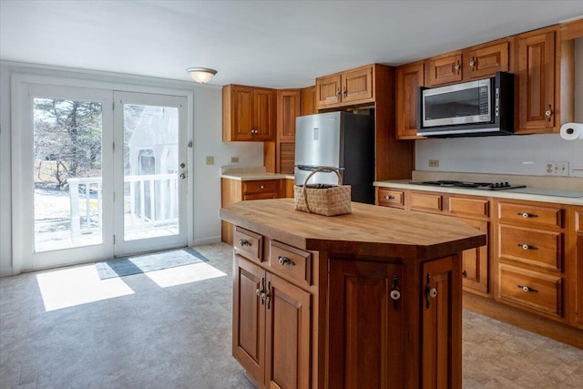 332 Back River Rd, Boothbay, ME 04537 - kitchen with appliances with stainless steel finishes, wooden counters, brown cabinets, a kitchen island, and light flooring
