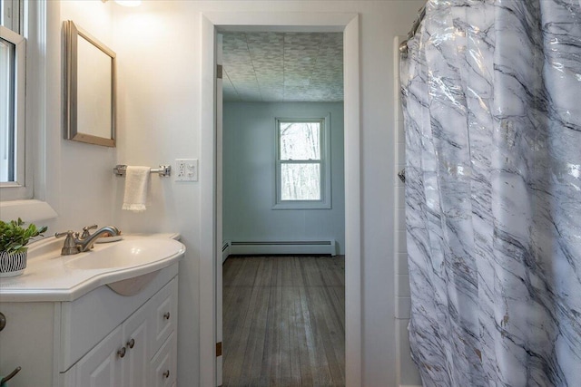 332 Back River Rd, Boothbay, ME 04537 - full bathroom with a baseboard radiator, vanity, wood finished floors, and a shower with curtain