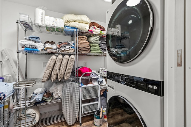 laundry room with laundry area, wood finished floors, and stacked washer and dryer