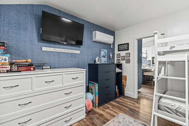 bedroom featuring dark wood-style floors and a wall mounted air conditioner