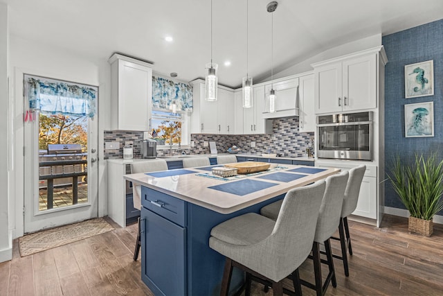 kitchen featuring custom exhaust hood, white cabinets, light countertops, and oven