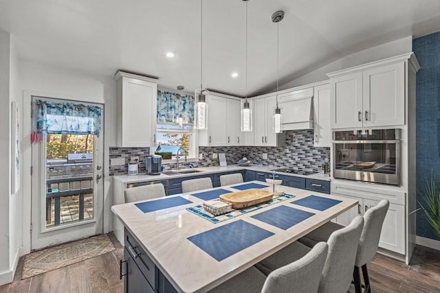 kitchen featuring oven, a sink, dark wood-style flooring, and white cabinetry