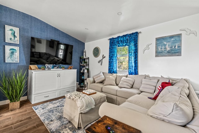 living room with an accent wall, vaulted ceiling, dark wood-type flooring, and wallpapered walls