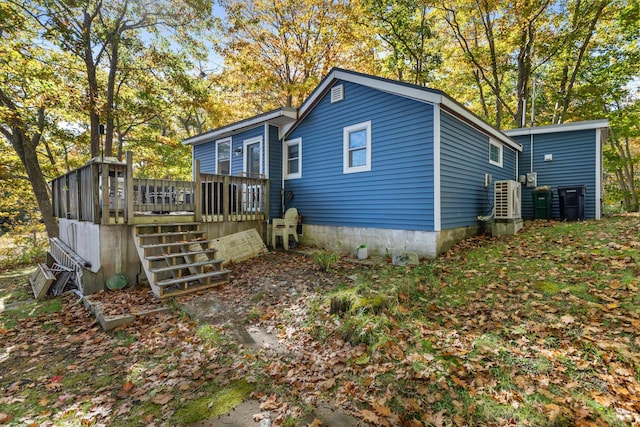 back of property with stairs and a deck