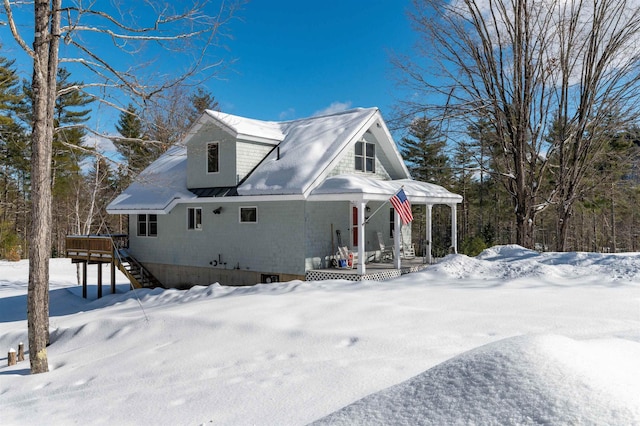 snow covered property featuring stairway