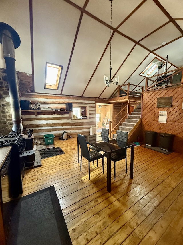 playroom with wood-type flooring, vaulted ceiling, and log walls