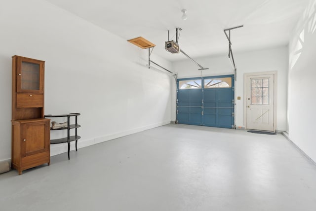 garage with a garage door opener and baseboards