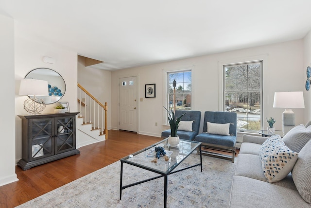 living room with stairway, wood finished floors, baseboards, and a baseboard radiator