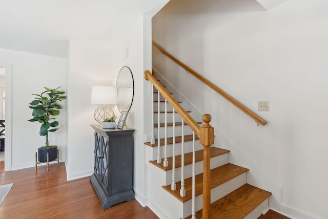 stairway with baseboards and wood finished floors