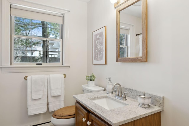 bathroom featuring toilet, vanity, and a baseboard radiator