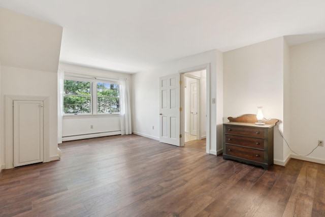 unfurnished bedroom featuring baseboard heating, baseboards, and wood finished floors