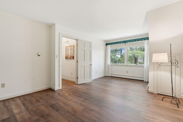 unfurnished bedroom with wood finished floors, baseboards, and baseboard heating