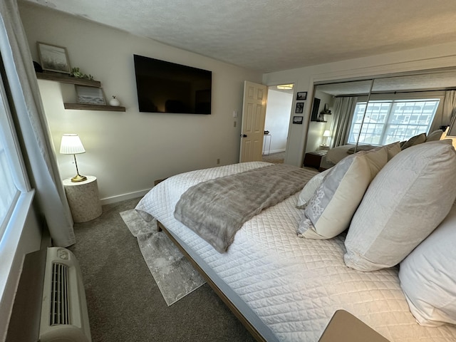 bedroom with a textured ceiling, carpet, and baseboards