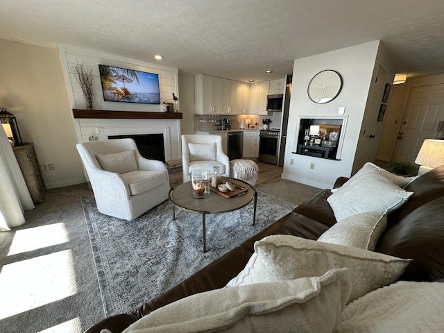 living area with recessed lighting, a fireplace, a textured ceiling, and baseboards